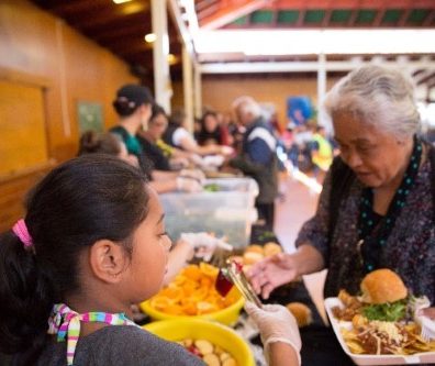 An old woman filling food plate