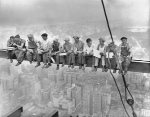 Construction workers taking a break on a steel beam.